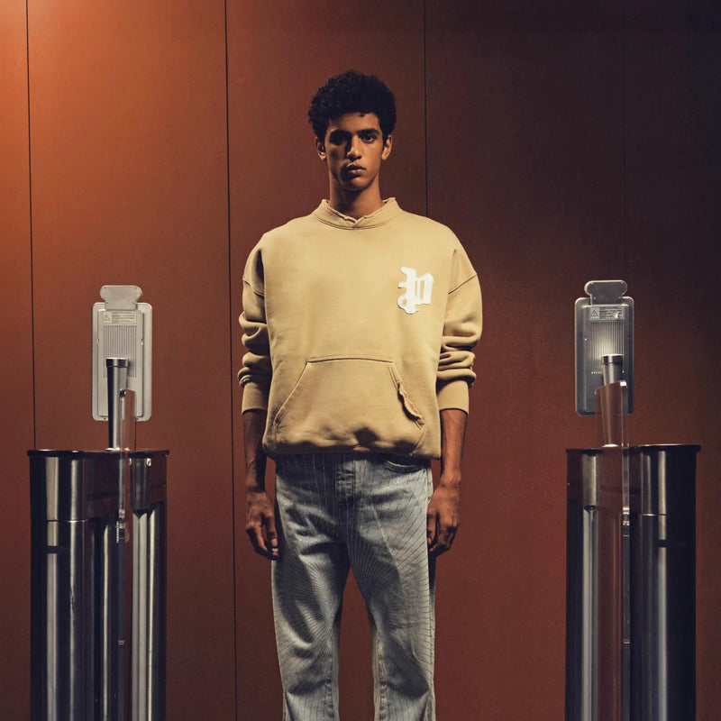 Beige hoodie with a white embroidered logo on the chest.