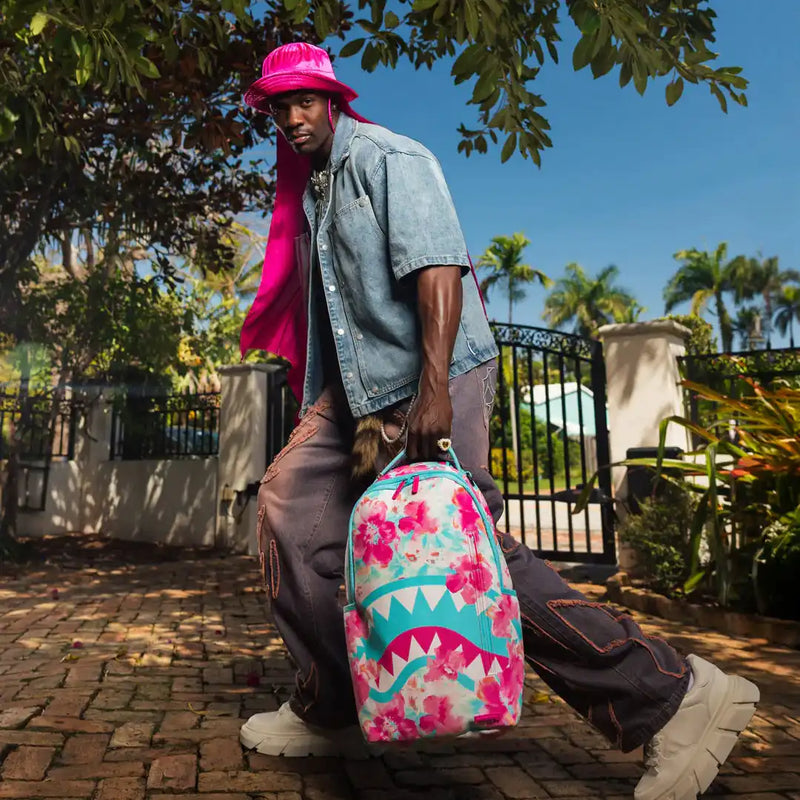 A floral and shark-mouth patterned backpack with vibrant pink and teal colors.