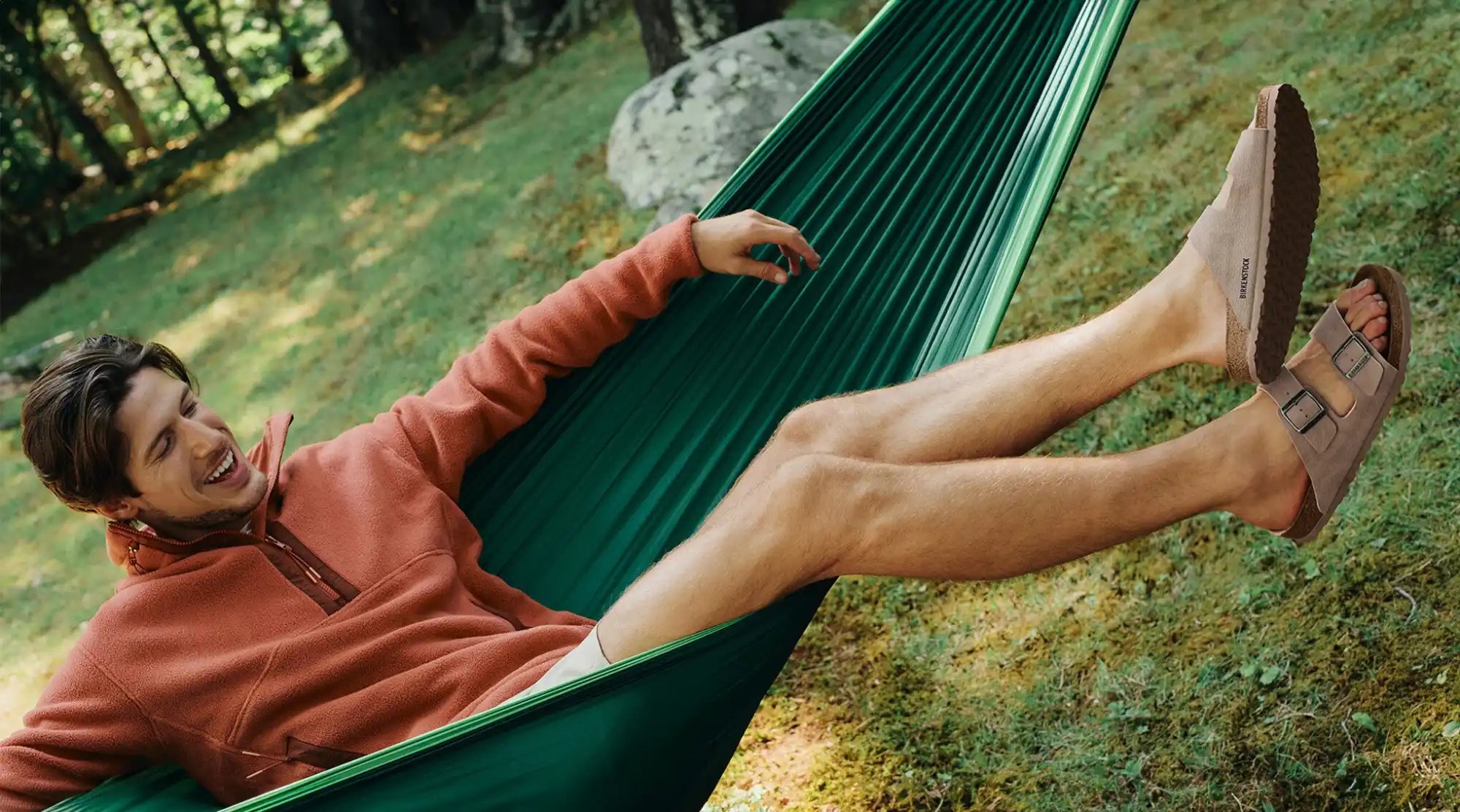 Man in a hammock wearing sandals.